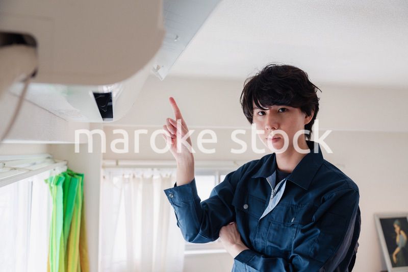 エアコンの点検をする男性