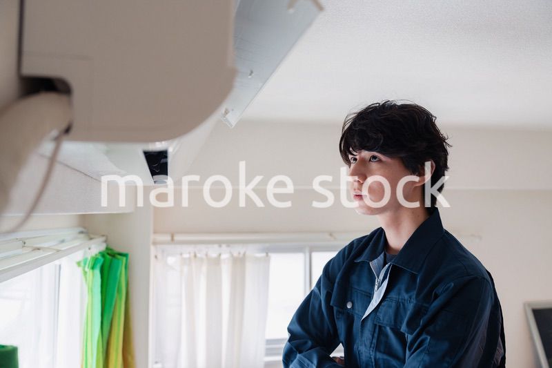 エアコンの点検をする男性