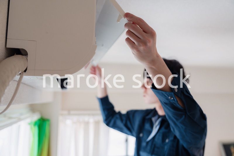 エアコンの点検をする男性