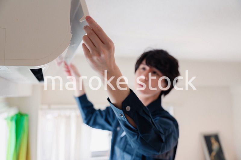 エアコンの点検をする男性