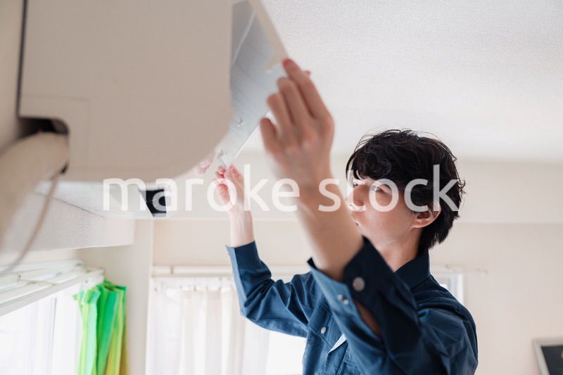 エアコンの点検をする男性
