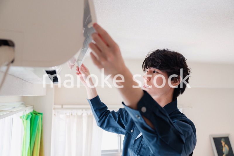 エアコンの点検をする男性