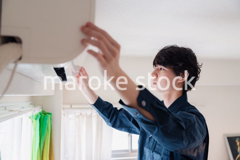 エアコンの点検をする男性