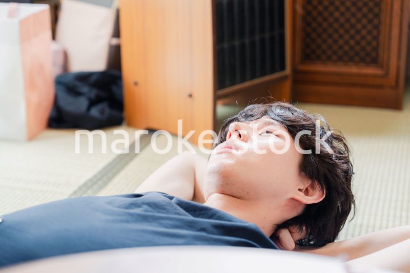 実家で寝転がる若い男性