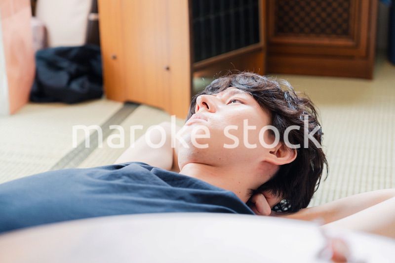 実家で寝転がる若い男性