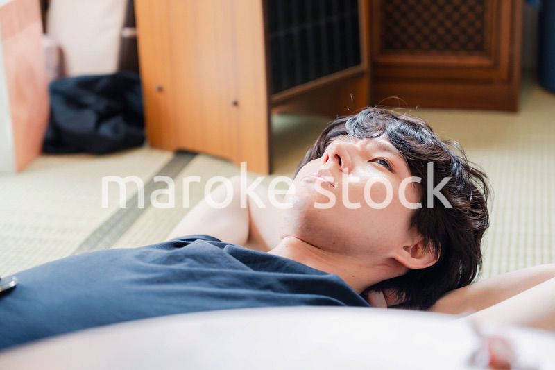 実家で寝転がる若い男性
