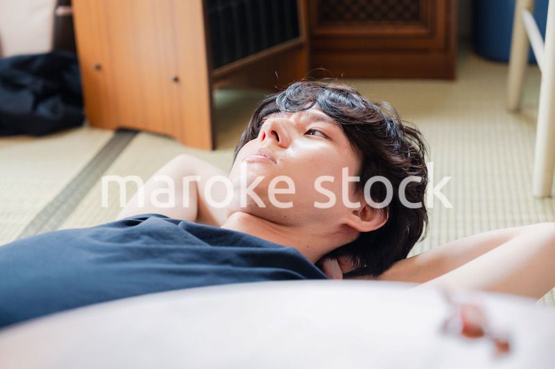 実家で寝転がる若い男性
