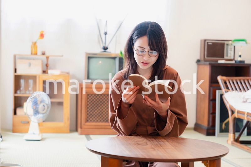 古風な雰囲気の家で読書をする若い女性