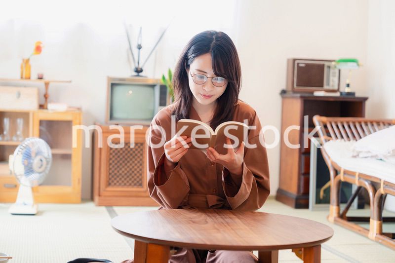 古風な雰囲気の家で読書をする若い女性