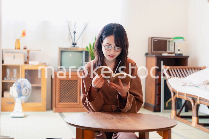 古風な雰囲気の家で読書をする若い女性