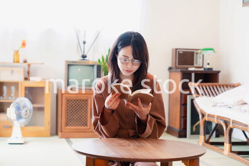 古風な雰囲気の家で読書をする若い女性