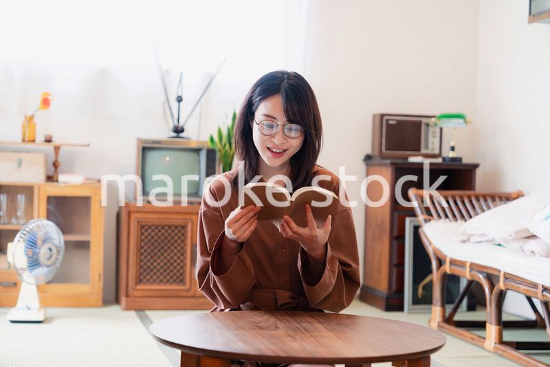 古風な雰囲気の家で読書をする若い女性