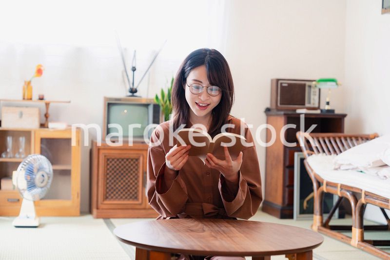 古風な雰囲気の家で読書をする若い女性