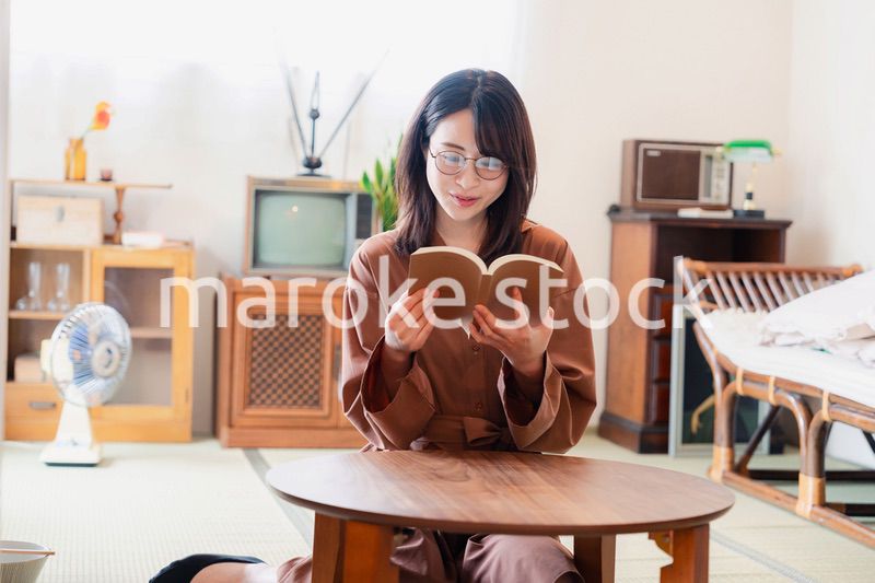 古風な雰囲気の家で読書をする若い女性