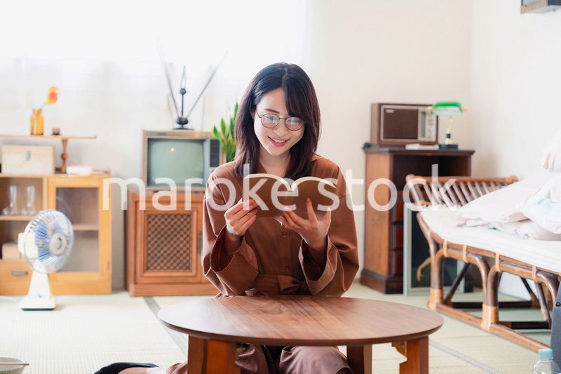 古風な雰囲気の家で読書をする若い女性