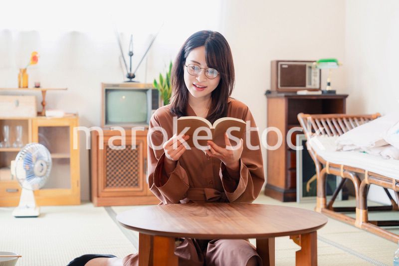 古風な雰囲気の家で読書をする若い女性