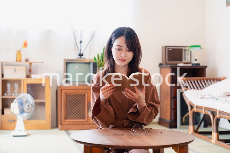 古風な雰囲気の家で読書をする若い女性