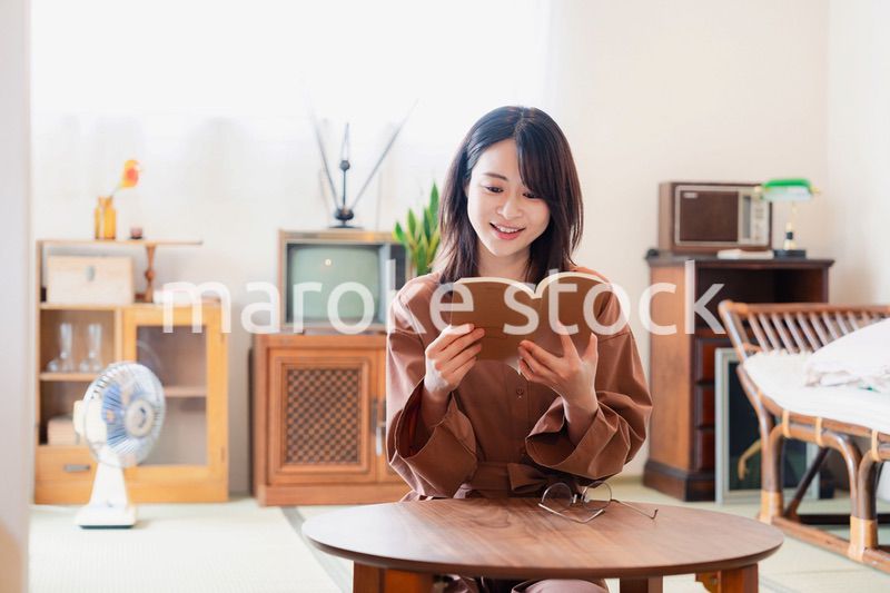 古風な雰囲気の家で読書をする若い女性