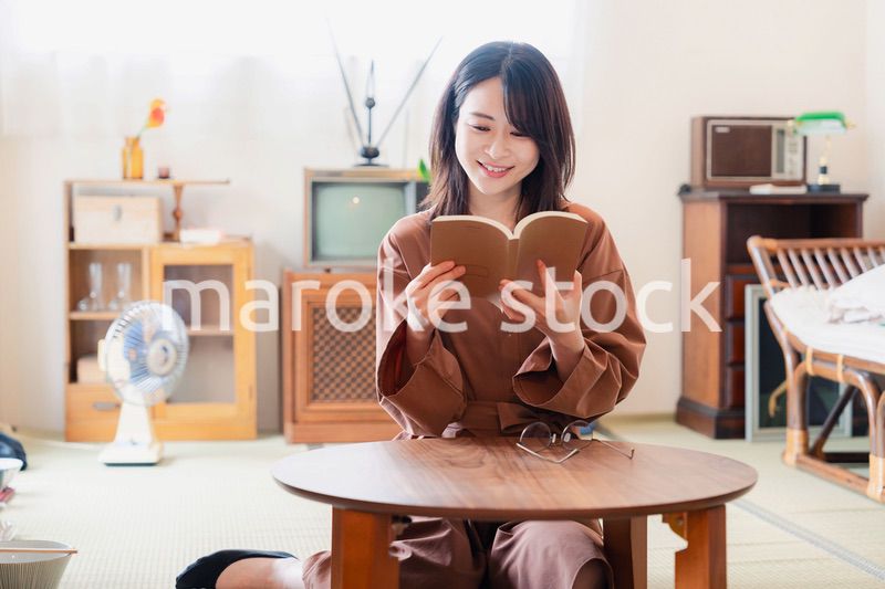 古風な雰囲気の家で読書をする若い女性