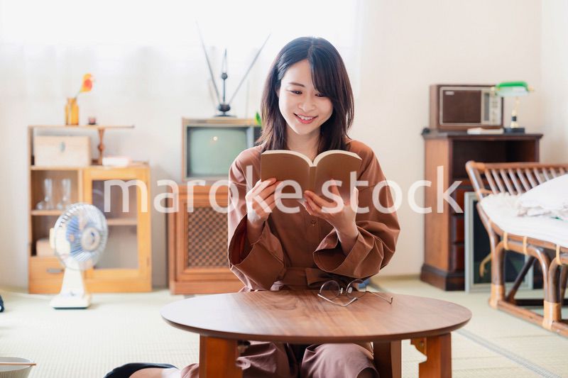 古風な雰囲気の家で読書をする若い女性