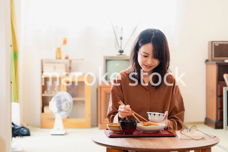 和室でご飯を食べる若い女性