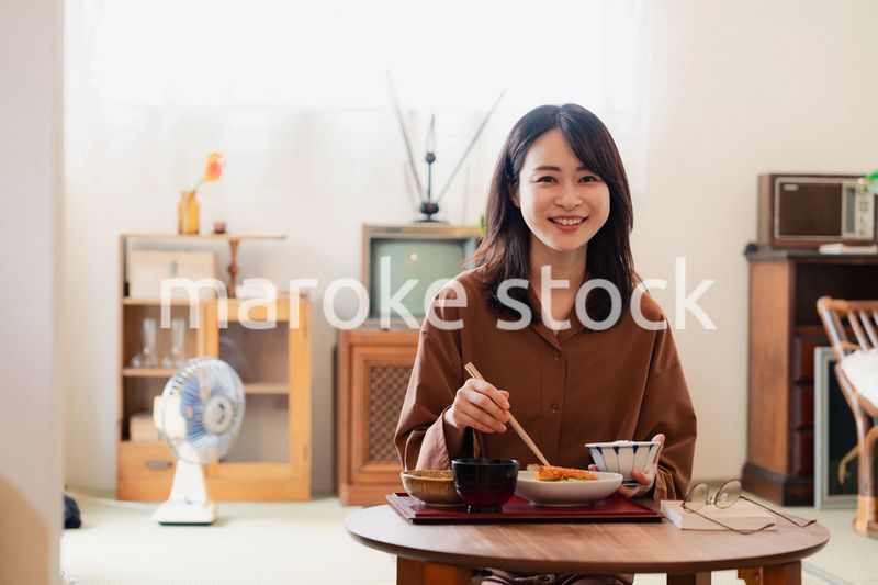 和室でご飯を食べる若い女性