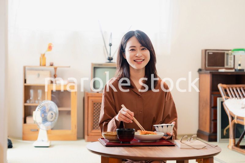 和室でご飯を食べる若い女性