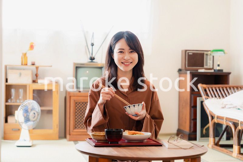 和室でご飯を食べる若い女性