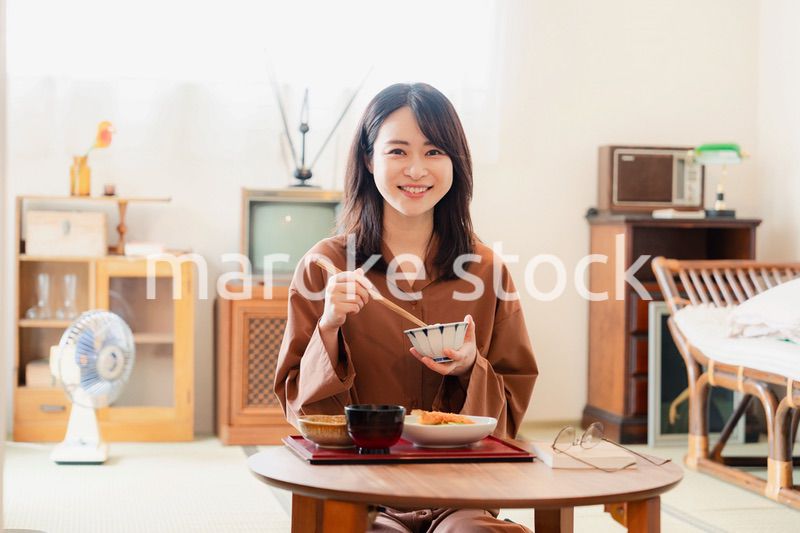 和室でご飯を食べる若い女性