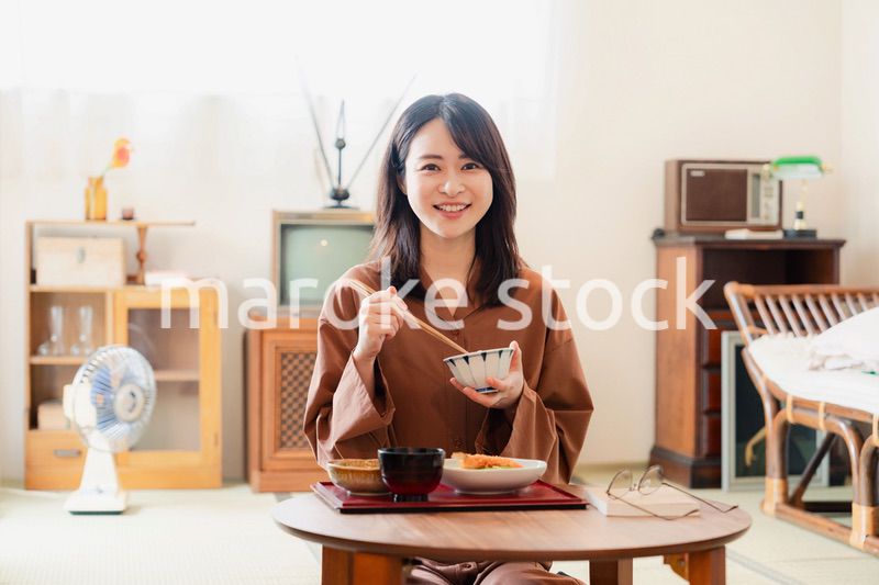 和室でご飯を食べる若い女性