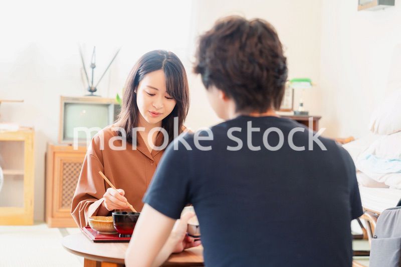 ドラマのようなレトロな雰囲気の食卓でごはんを食べる若い夫婦
