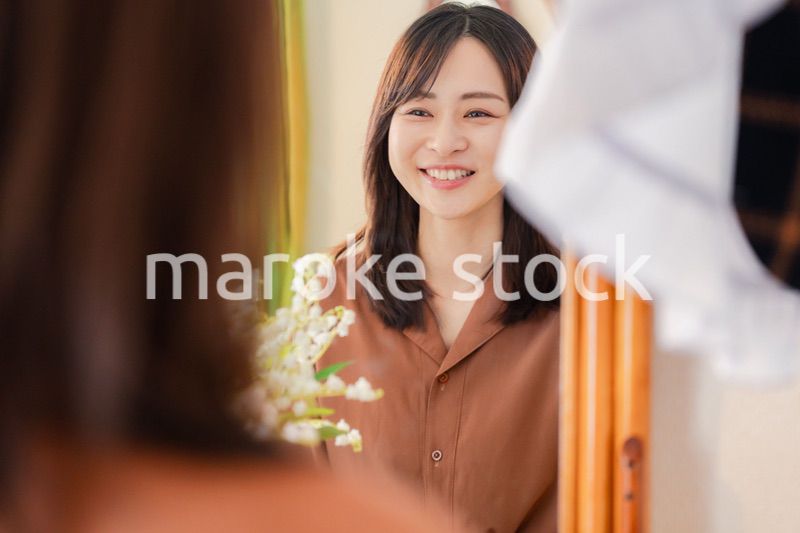 鏡台で身支度をする若い女性