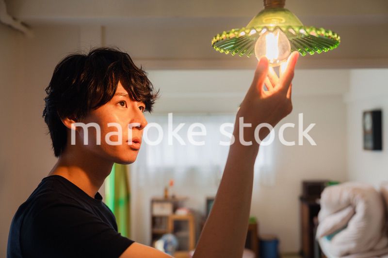 白熱電球を交換する若い男性