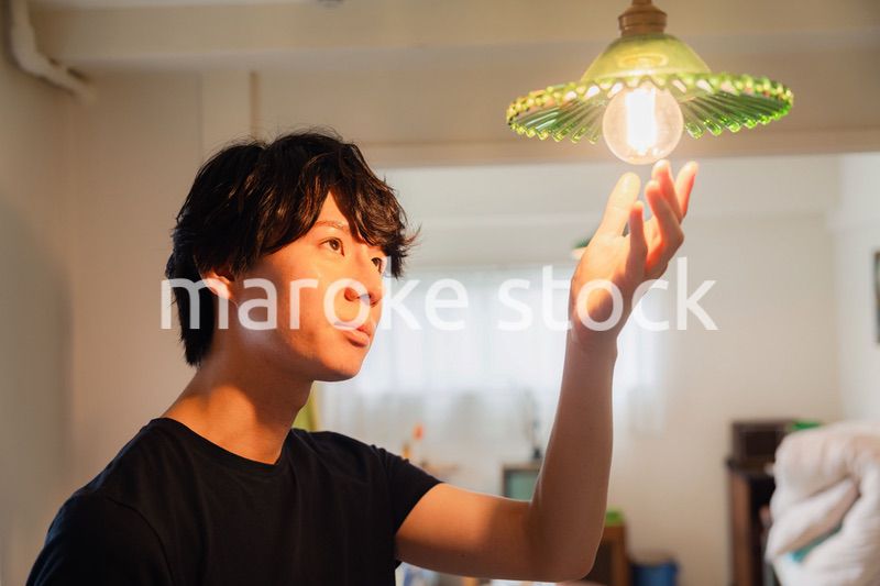 白熱電球を交換する若い男性