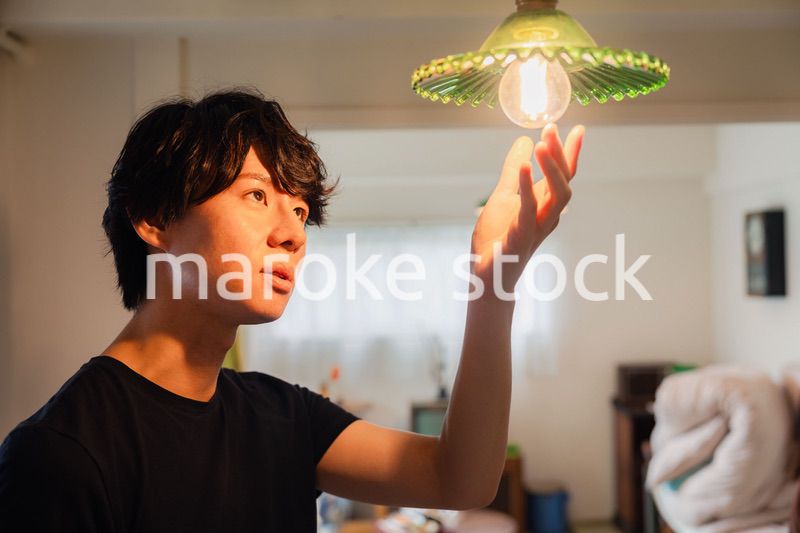 白熱電球を交換する若い男性