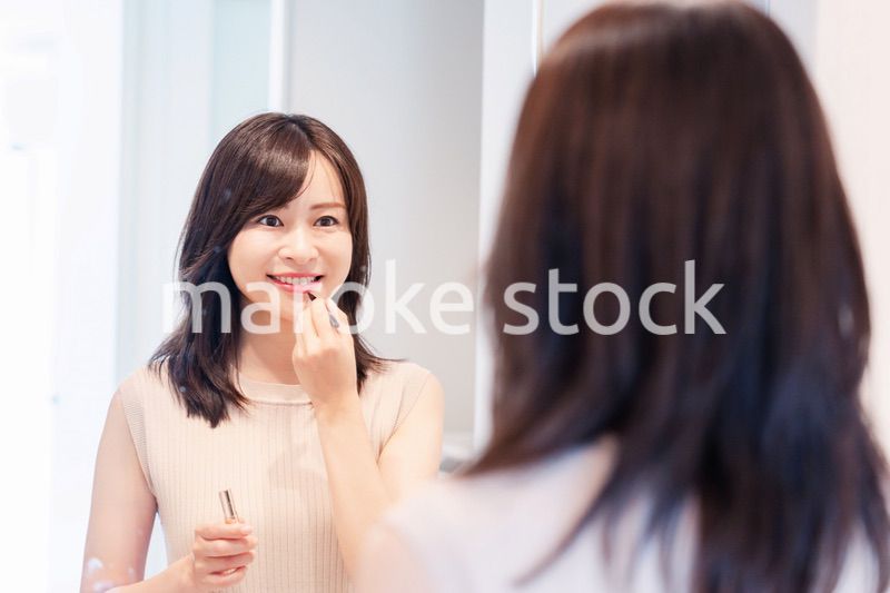 家でメイクをする若い女性