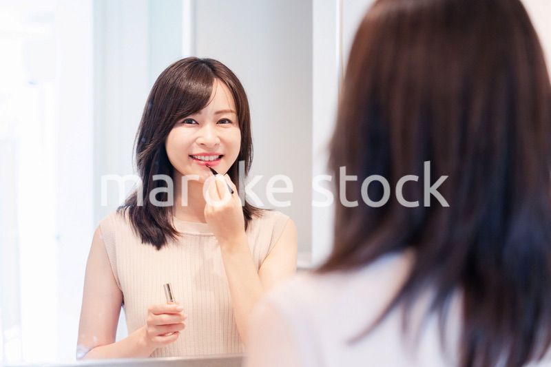 家でメイクをする若い女性