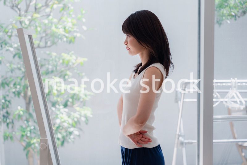 自分の体型を気にする若い女性