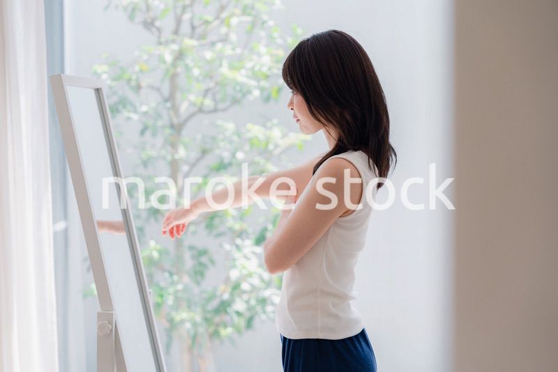 自分の体型を気にする若い女性