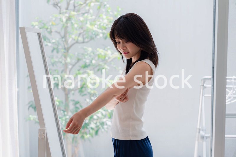 自分の体型を気にする若い女性