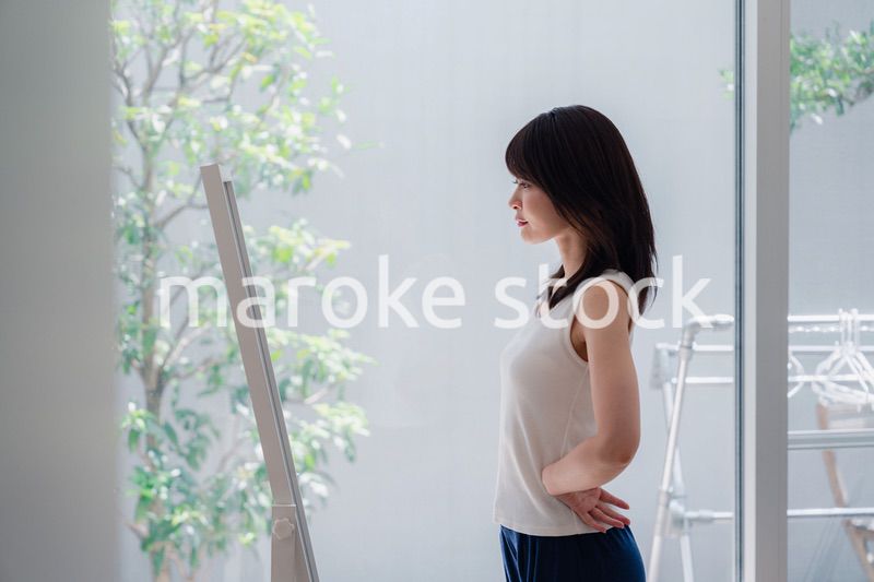 自分の体型を気にする若い女性