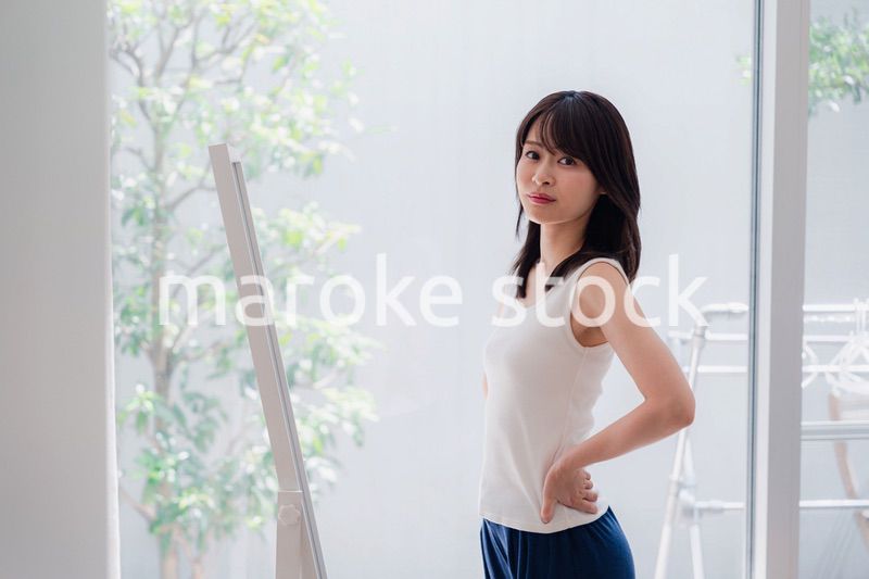 自分の体型を気にする若い女性