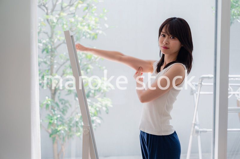 自分の体型を気にする若い女性