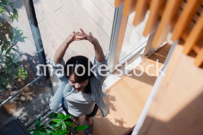 家の窓際で過ごす若い女性