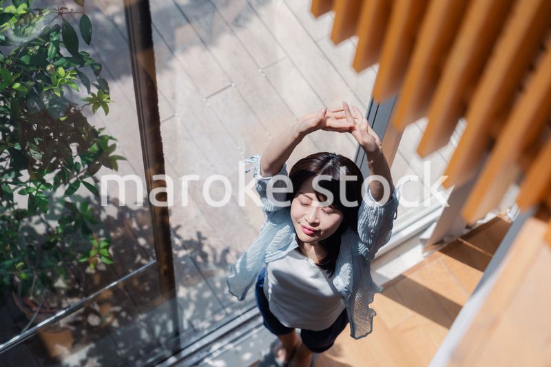 家の窓際で過ごす若い女性