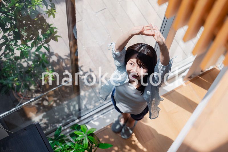 家の窓際で過ごす若い女性