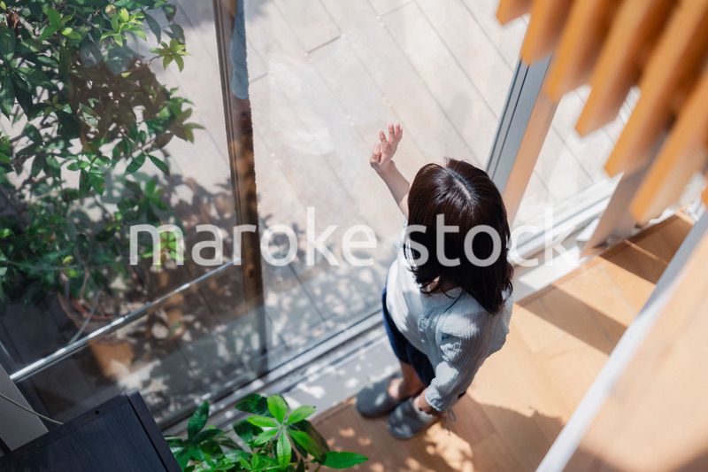 家の窓際で過ごす若い女性