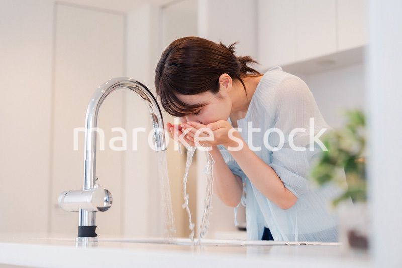 家で洗顔をする若い女性