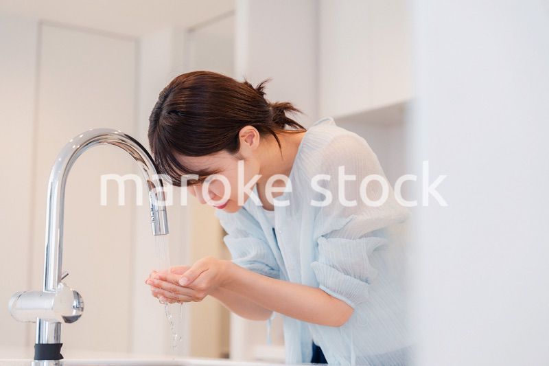 家で洗顔をする若い女性