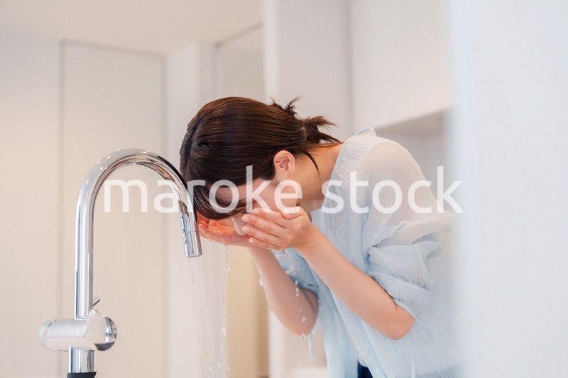 家で洗顔をする若い女性